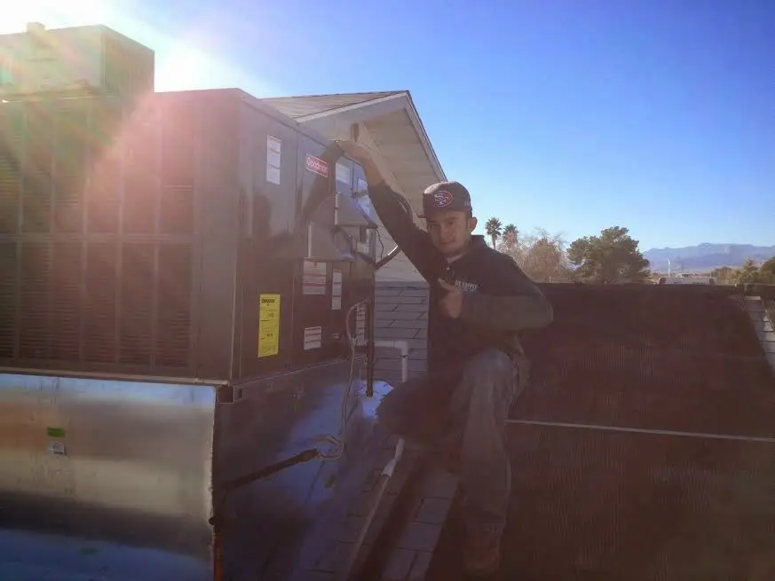 HVAC technician performing AC Tune-Up on a rooftop unit in Westchase
