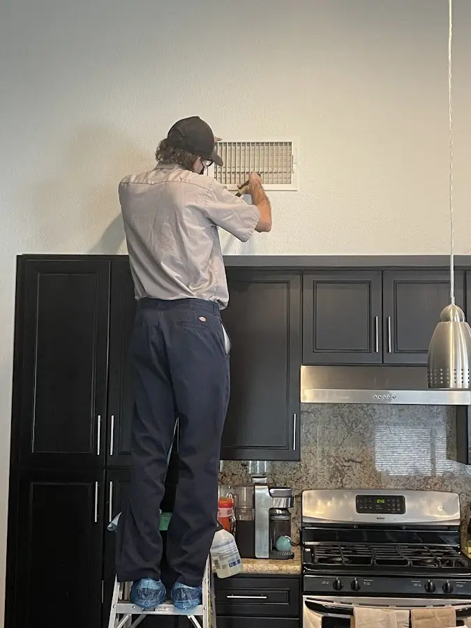 Technician inspecting an air vent during HVAC service in Westchase
